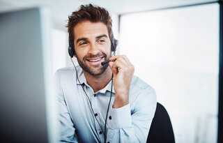 AdobeStock_491517672 young, call centre agent, working in an office. guy on phone,